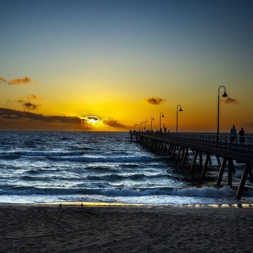 A scenic view of Henley Beach, showcasing the pristine sandy shorelines and crystal-clear waters, offering international students the opportunity to enjoy stand paddleboarding in a picturesque setting.