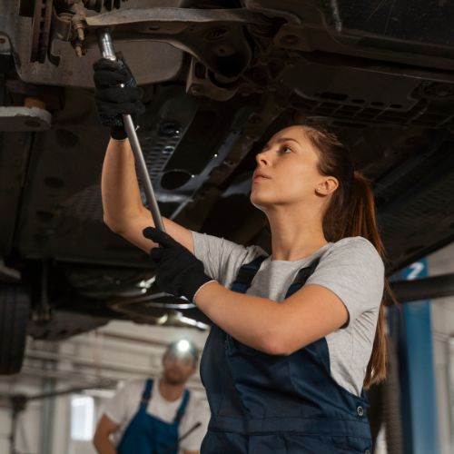 An accomplished female mechanic working on a car engine, representing our Pack 1 ONE program